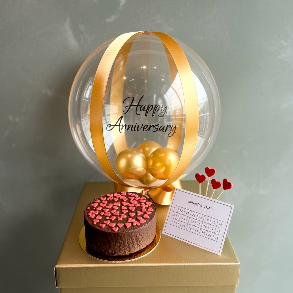Elegant Gold Balloon Anniversary Cake with Chocolate Heart Topping