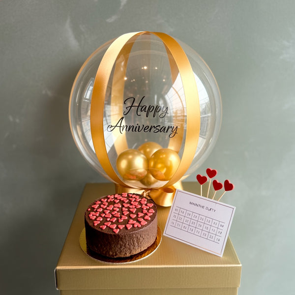 Elegant Gold Balloon Anniversary Cake with Chocolate Heart Topping
